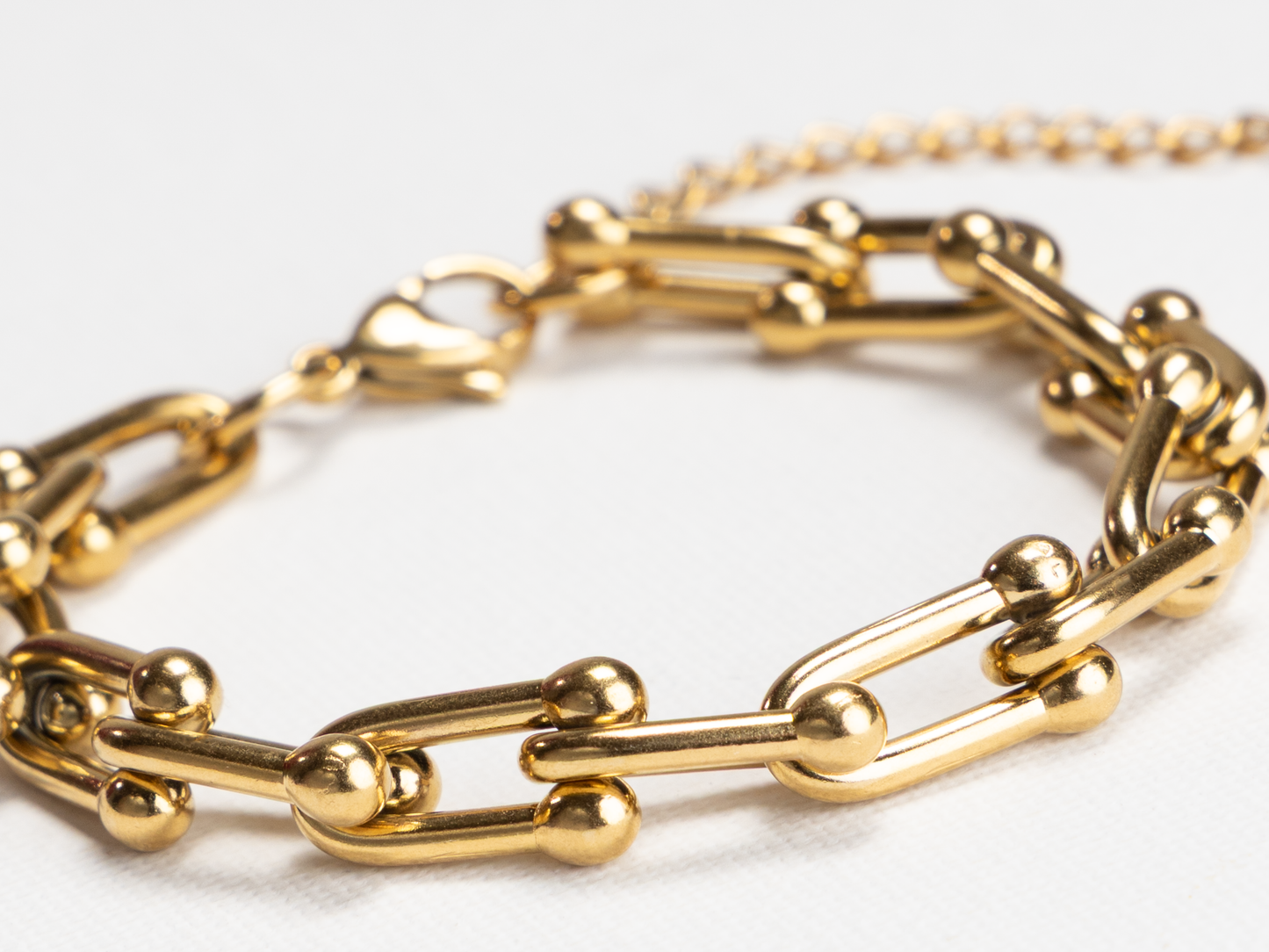 Gold chain bracelet on a white background