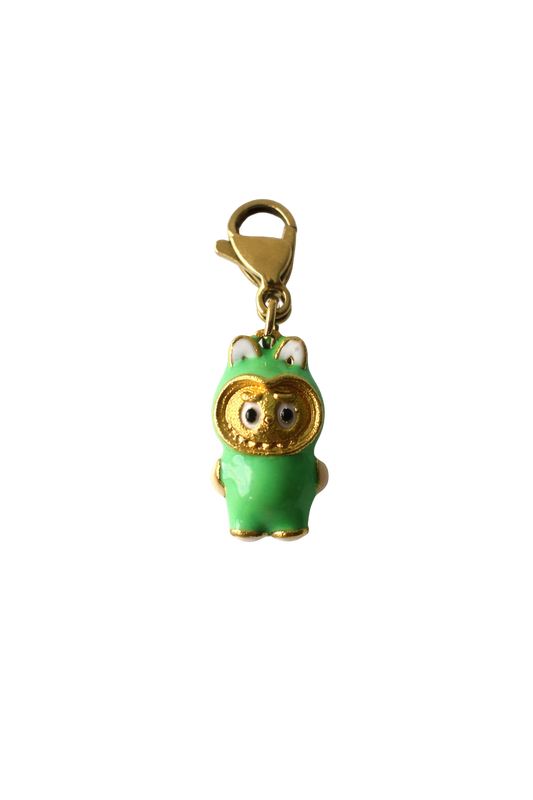 Green labubu charm with gold accents on a white background