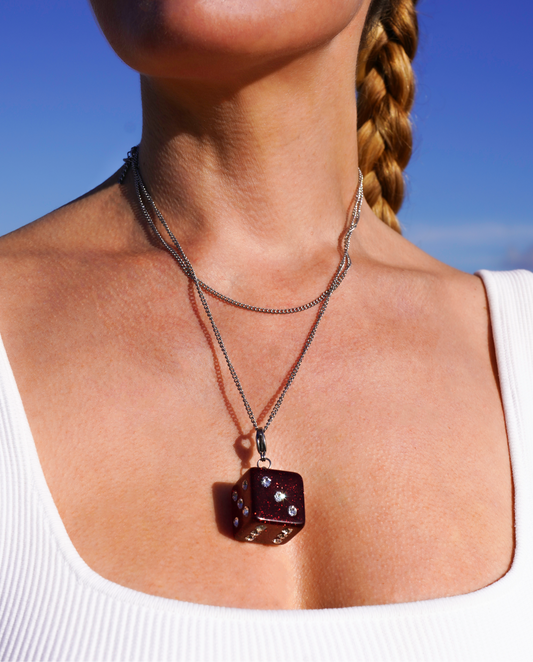 dice necklace girl in front of ntature