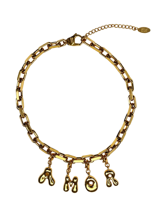 A gold-tone chunky chain MILLIE MADNESS necklace with dangling letter charms spelling 'AMOR', displayed on a clean white background.