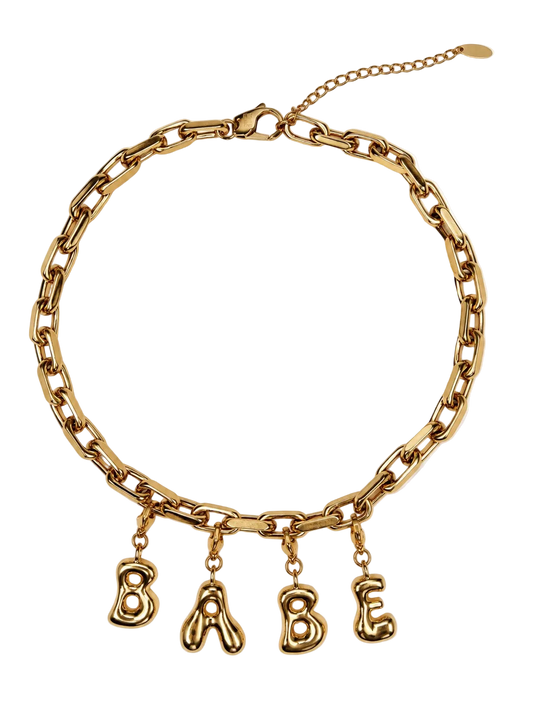Gold-tone chunky chain millie madness necklace with dangling letter charms spelling 'BABE' on a white background.