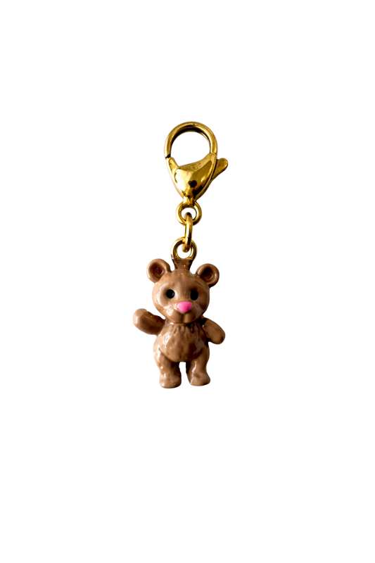 Gold teddy bear charm on a white background
