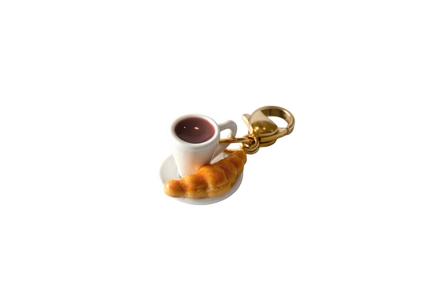 Keychain with a miniature cup of coffee and pastry on a white background