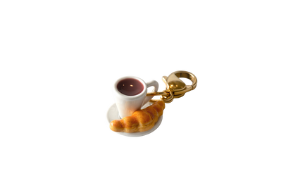Keychain with a miniature cup of coffee and pastry on a white background