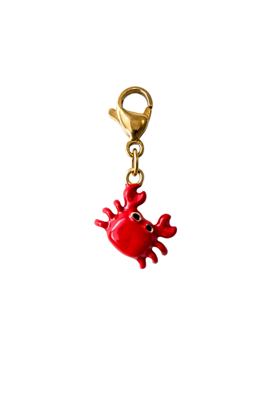 Red crab-shaped charm with gold clasp on a white background