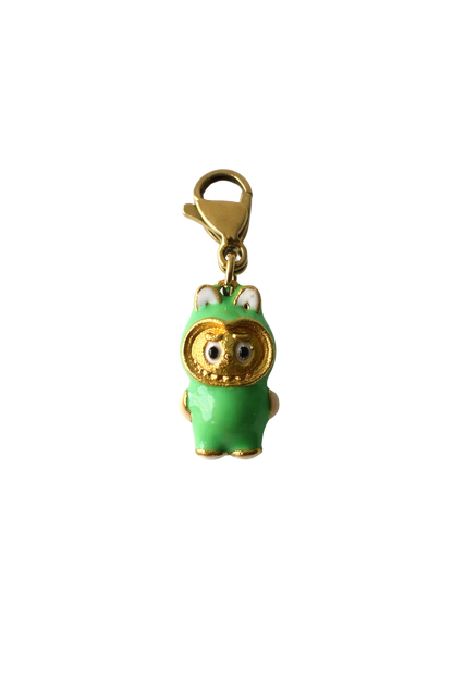 Green labubu charm with gold accents on a white background