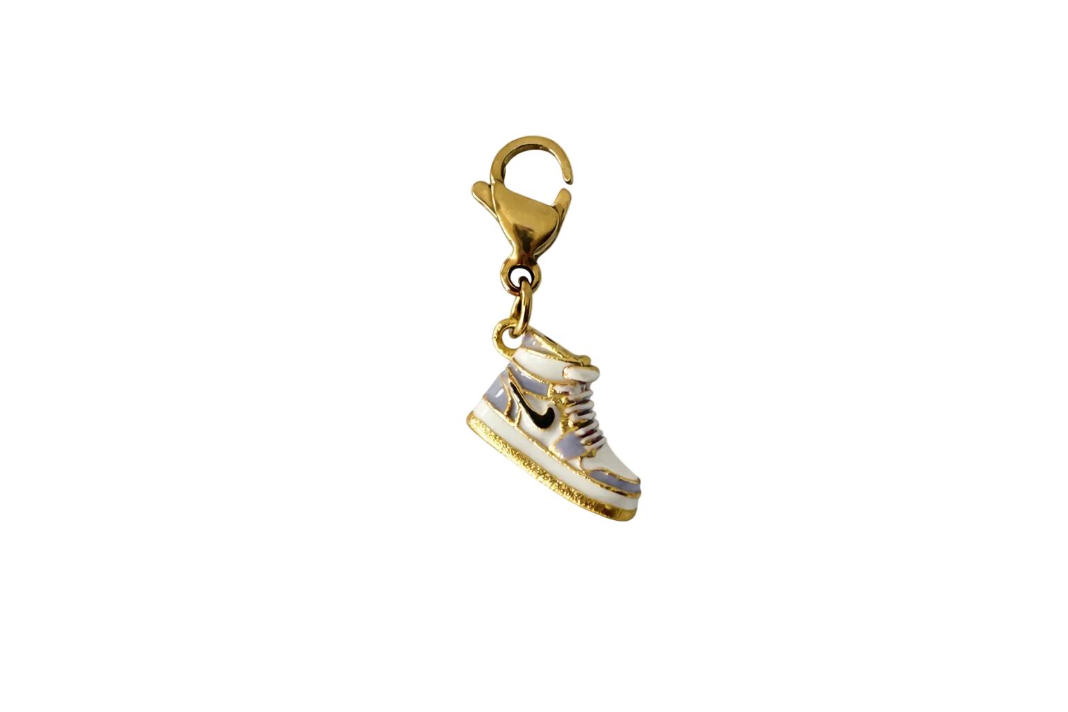 Gold and white sneaker charm on a white background