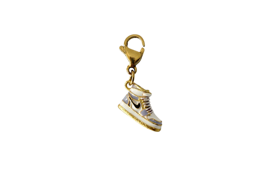 Gold and white sneaker charm on a white background