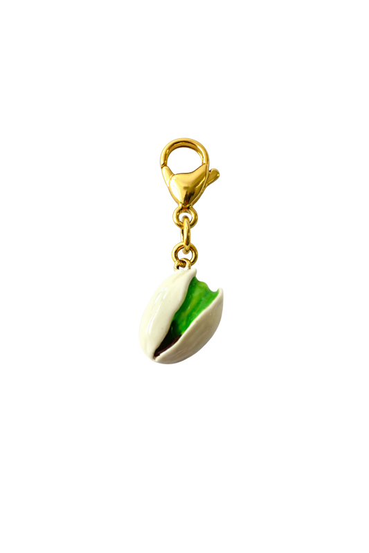 Pistachio-shaped charm with a gold clasp on a white background