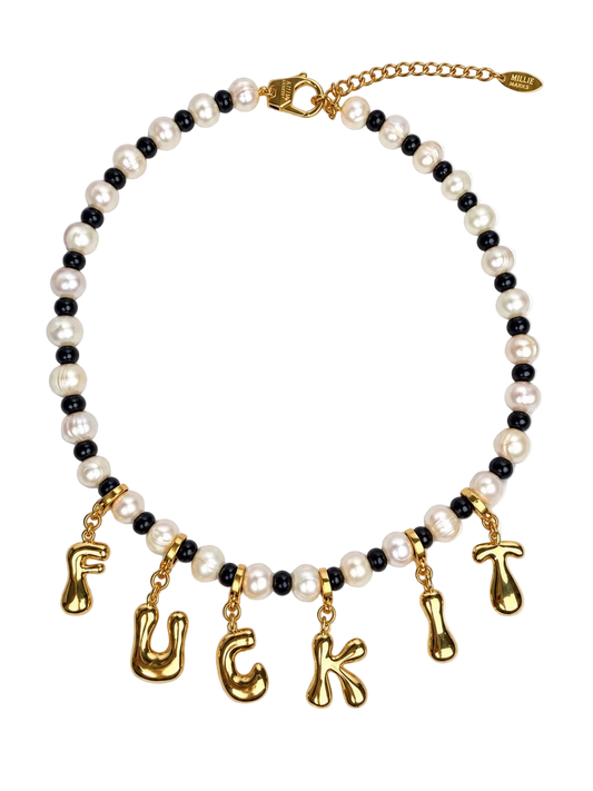 A gold-tone and black pearl MILLIE MADNESS necklace featuring white faux pearls and dangling gold letter charms spelling out 'FUCK' and 'IT' on a plain white background.