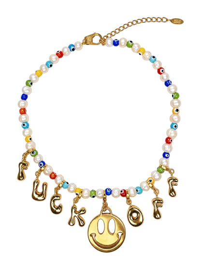 A gold-tone beaded millie madness necklace with white faux pearls, colorful evil eye beads, and dangling gold-tone letter charms spelling 'FUCK OF' around a large gold smiley face charm, shown on a white background.