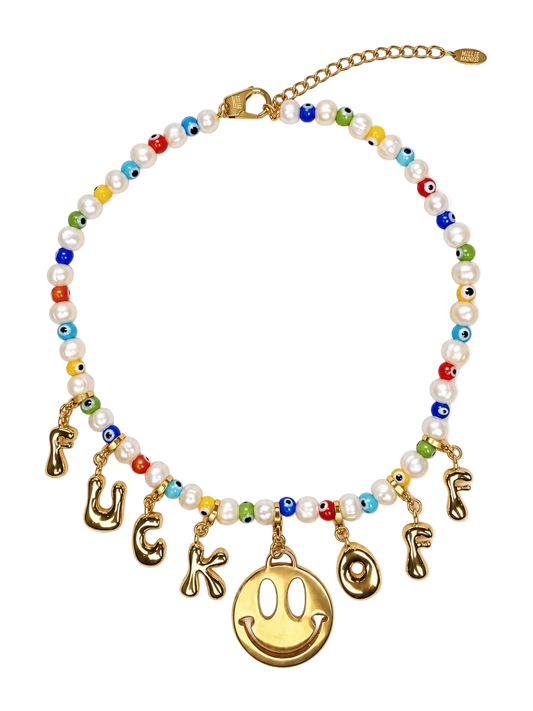 A gold-tone beaded millie madness necklace with white faux pearls, colorful evil eye beads, and dangling gold-tone letter charms spelling 'FUCK OF' around a large gold smiley face charm, shown on a white background.