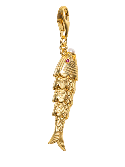 A gold fish-shaped charm pendant with a lobster clasp, featuring a small red gemstone for an eye and a white pearl for a mouth, shown against a plain white background.