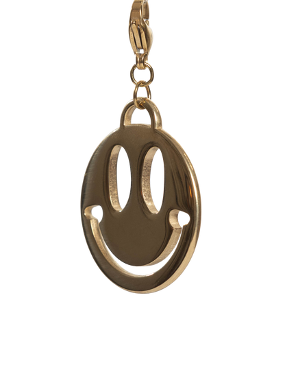 Gold stainless steel smiley face charm on a white background