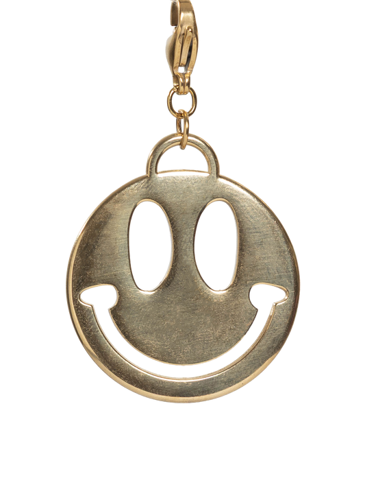 Gold stainless steel smiley face charm on a white background
