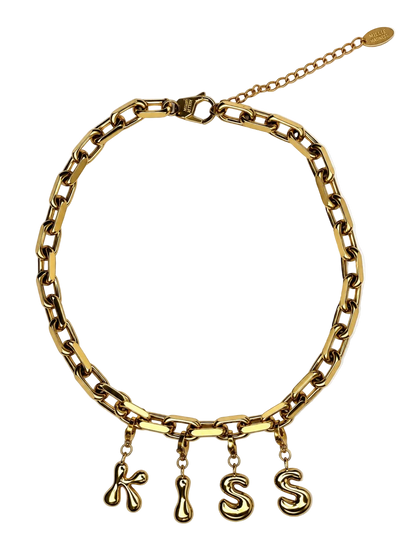 A gold-toned chain millie madness necklace with four dangling letter charms spelling 'KISS' in a stylized font, displayed on a clean white background.
