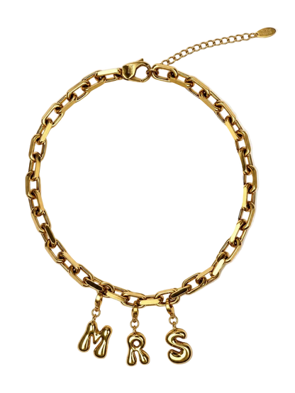 A gold-colored chunky chain MILLIE MADNESS necklace with three dangling letter charms spelling 'MRS' in a cursive font, displayed on a clean white background.