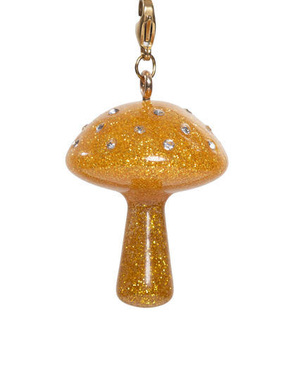 Gold glittery mushroom charm with rhinestones on a gold stainless steel clasp on a white background
