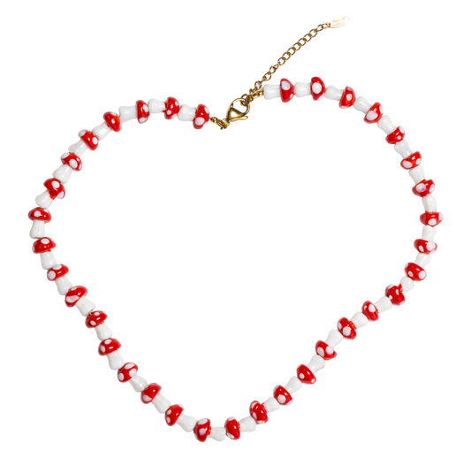 Necklace with red and white mushroom-shaped beads forming a heart shape on a white background