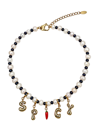 A beaded MILLIE MADNESS necklace featuring white faux pearls and small dark blue beads, with gold-tone letter charms spelling 'S.P.