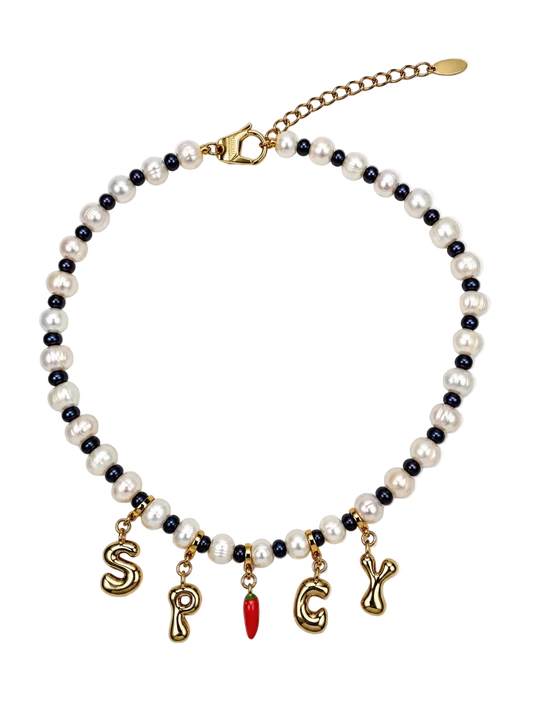 A beaded MILLIE MADNESS necklace featuring white faux pearls and small dark blue beads, with gold-tone letter charms spelling 'S.P.