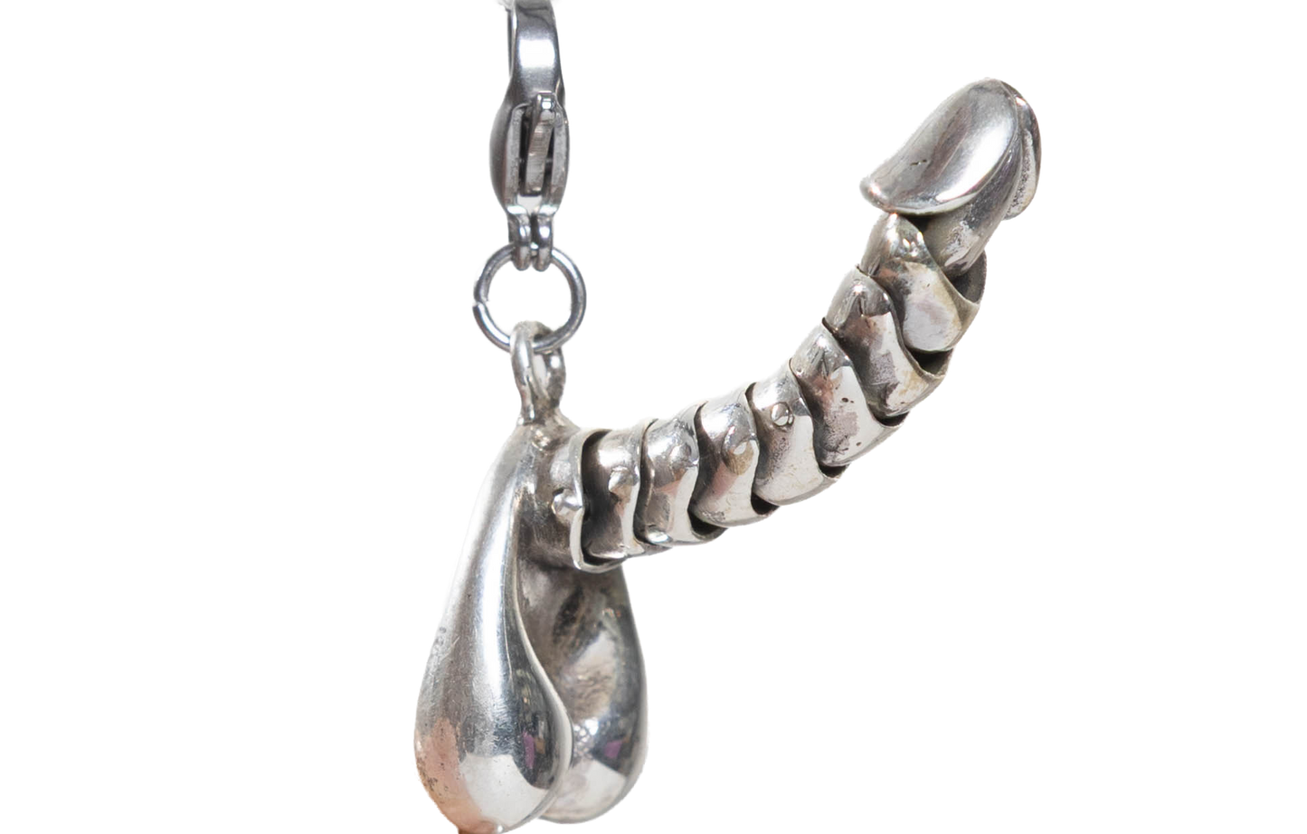 Silver penis charm on a white background