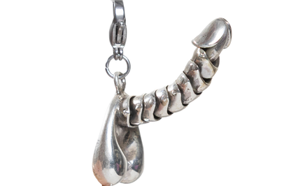 Silver penis charm on a white background
