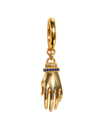 A gold hand-shaped millie madness earring pendant with a small ring of blue gemstones at the wrist, suspended from a gold loop, shown on a plain white background.