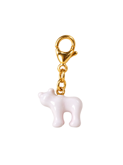 A small glossy white cow charm with a gold-tone lobster clasp and chain, isolated on a white background.