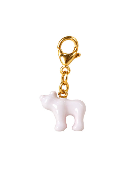 A small glossy white cow charm with a gold-tone lobster clasp and chain, isolated on a white background.