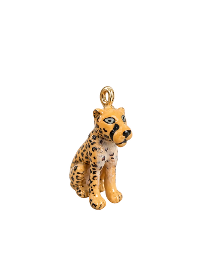 A small seated leopard charm with a gold-tone loop at the top, featuring a yellow-orange coat with black spots and blue eyes, photographed on a clean white background.