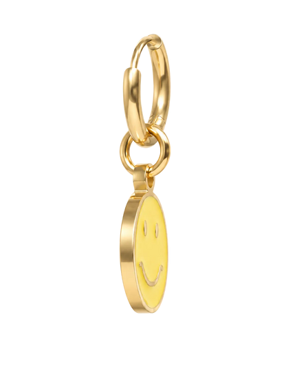 A gold hoop millie madness earring with a dangling oval charm featuring a smiley face, shown on a plain white background.