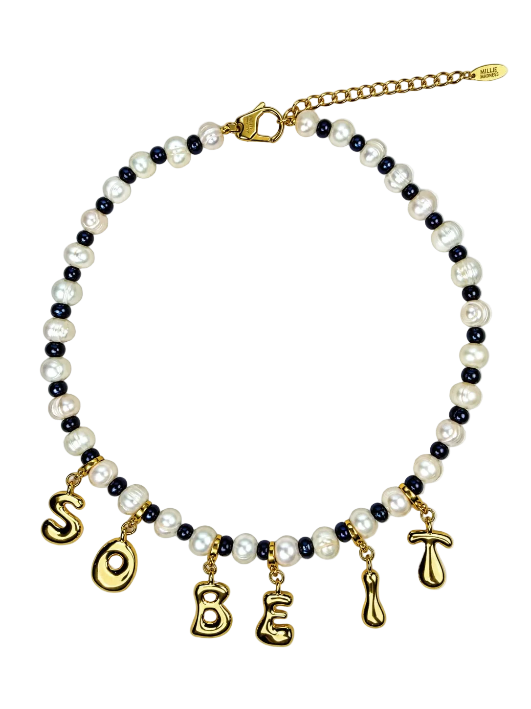 A beaded MILLIE MADNESS necklace featuring white faux pearls, dark navy blue beads, and gold-toned metal charms spelling 'SO BE' with additional gold charms, shown on a plain white background.