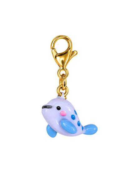 A small charm keychain featuring a cute, stylized whale character in pastel lavender, light blue, and pink, attached to a shiny gold lobster clasp, isolated on a white background.