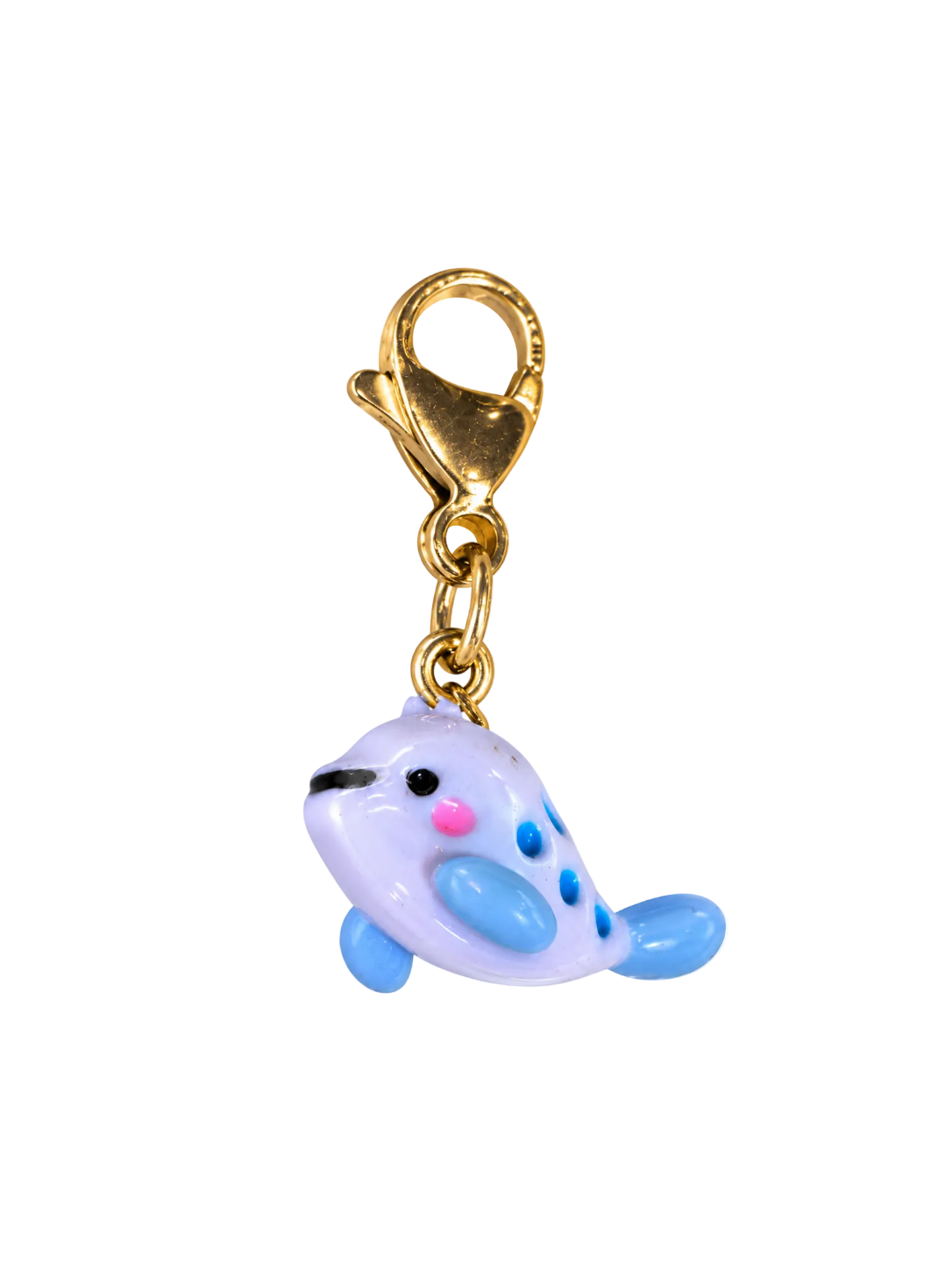 A small whale-shaped charm with a gold lobster clasp, featuring a pale lavender body, light blue flippers and spots, and pink and black facial details, isolated on a white background.